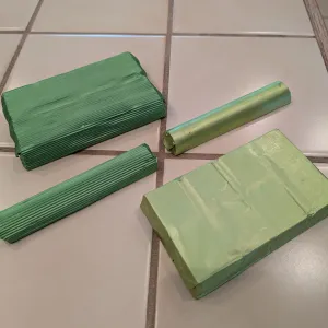 Four pieces of green chocolates on a light tiled surface.